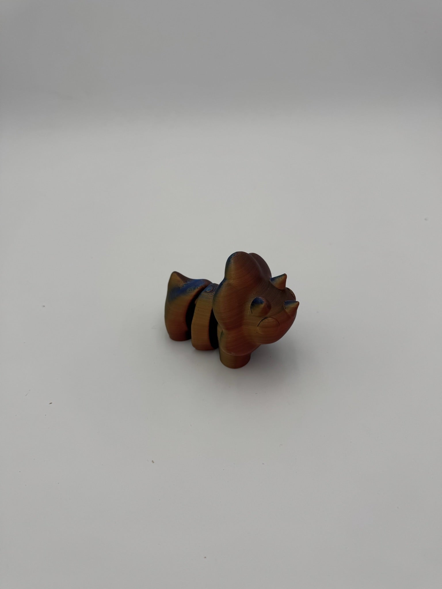 Stylized prehistoric dinosaur desk toy crafted from 100% recycled plastic.